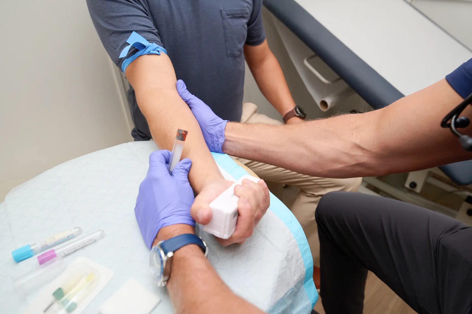 A PrimeCare clinician performing a blood draw at the exam table inside the Mobile Medical Office