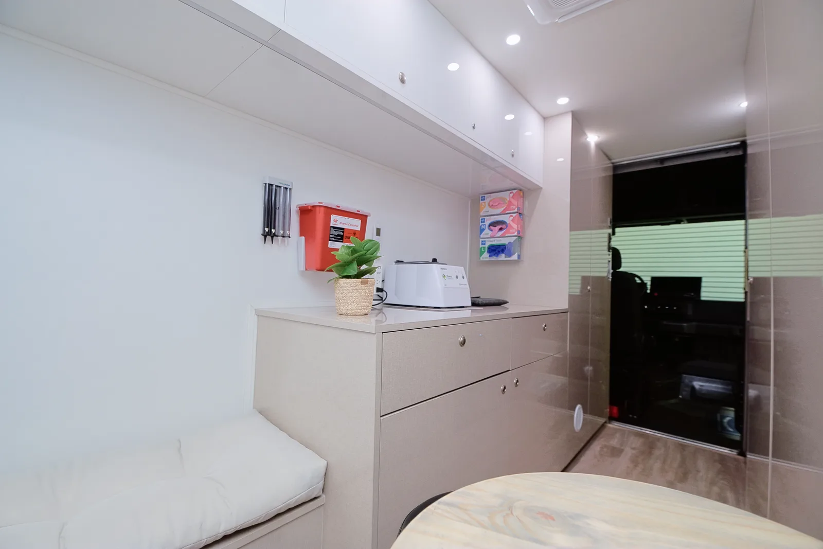 Interior cabin of the PrimeCare Mobile Medical Office showing storage cabinetry, exam supplies, and cushioned seating